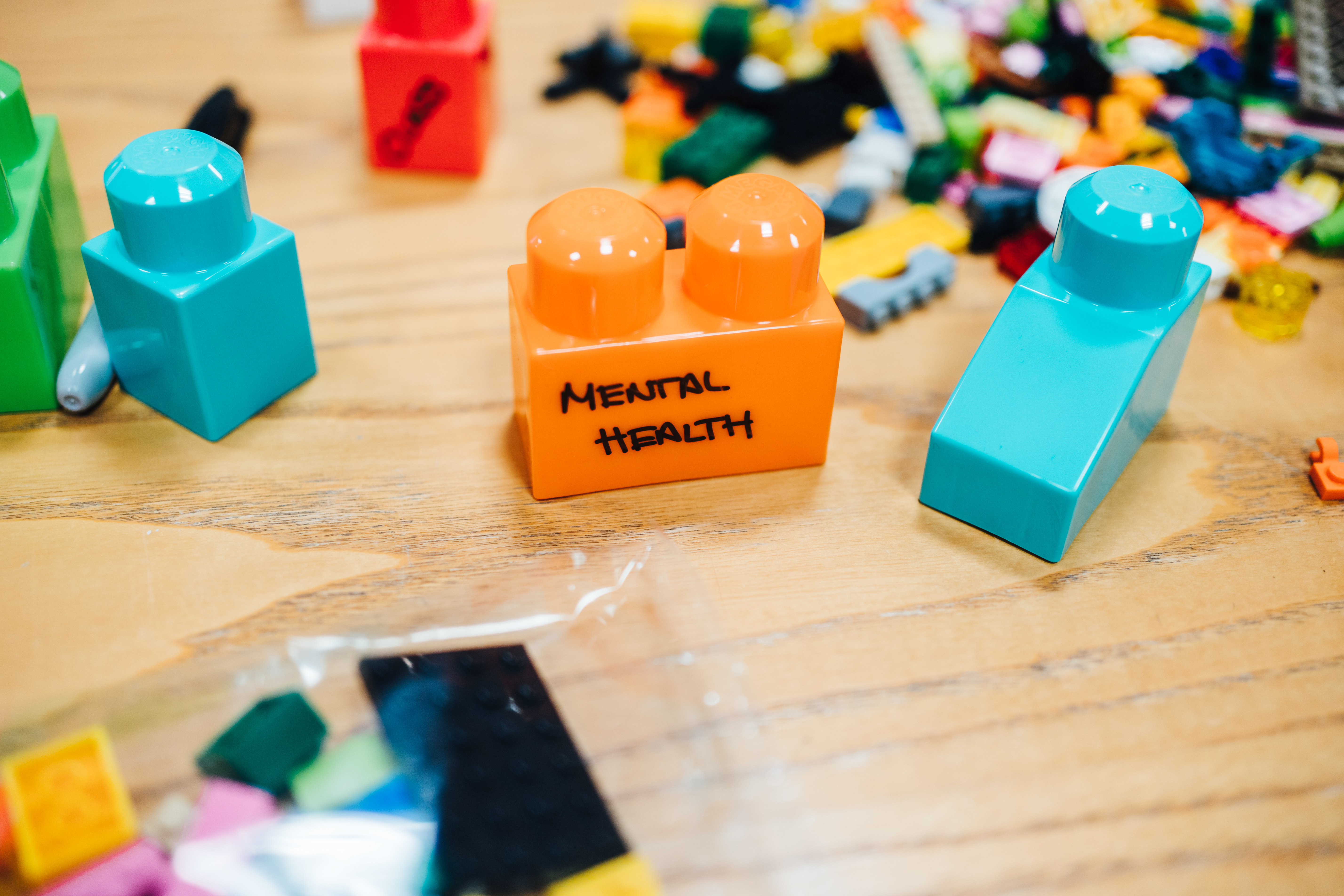 A table with lego on, the middle piece written with sharpie "Mental Health"